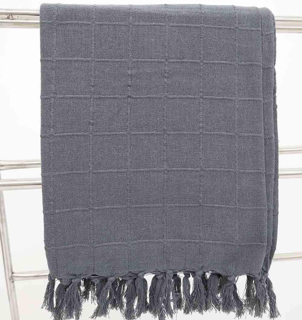 The Ramsha Home Living Room ThrowDark Grey Color TAL 053 (130x160cm) features a dark grey cotton fabric with a subtle checkered pattern and elegant fringe tassels, displayed on a metal rack.