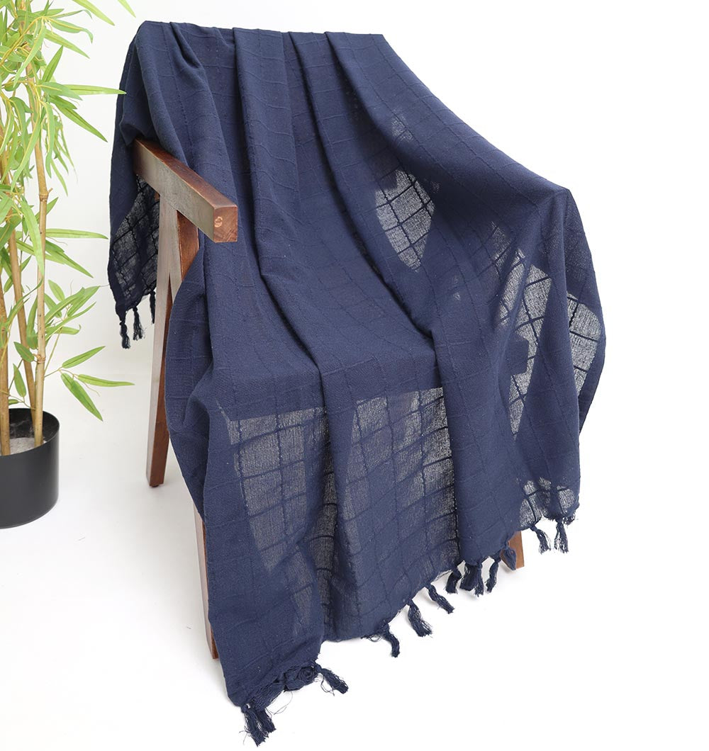 The Ramsha Home Living Room Throw Navy Blue Color TAL 055 (130x160cm) adds a stylish accent, featuring textured fringe edges, draped beside a bamboo plant for an elegant touch to your decor.