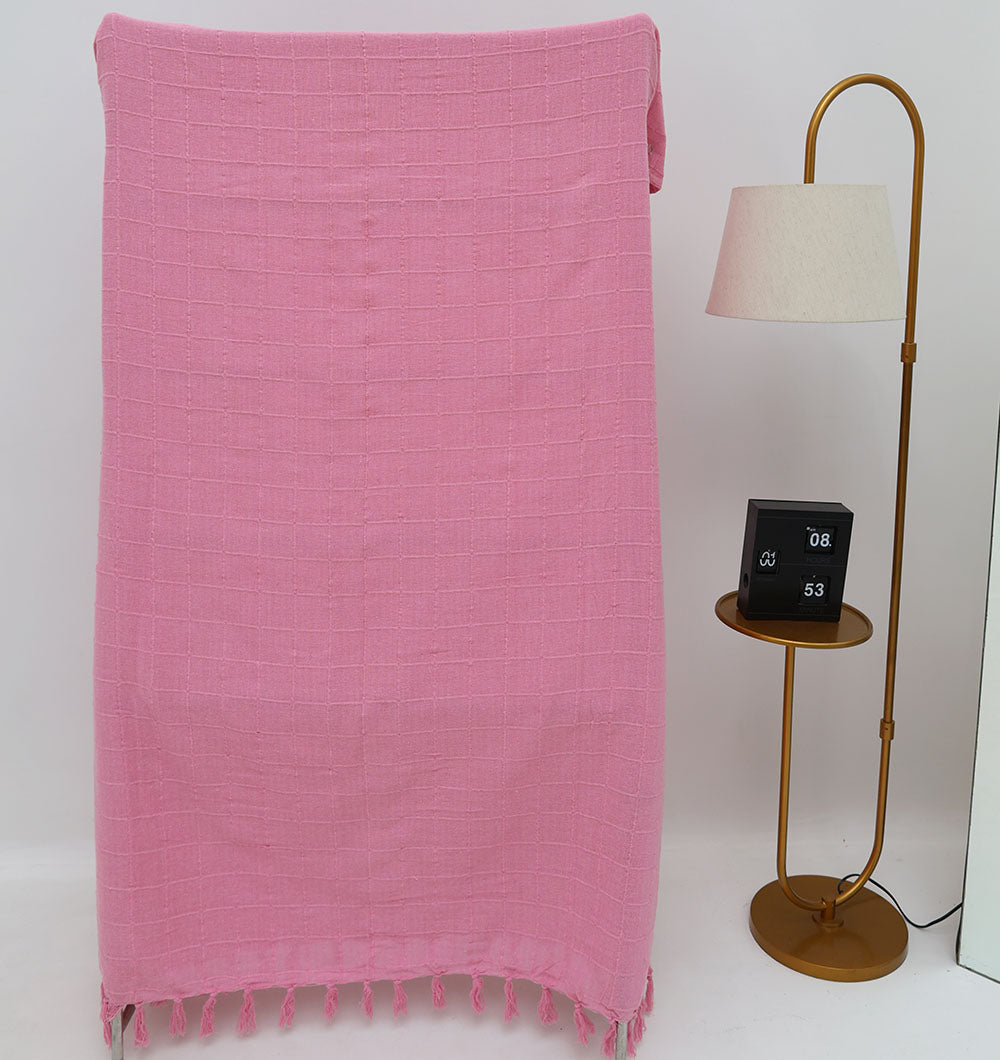 The Living Room Throw Pink Color TAL 056 (130x160cm) by Ramsha Home adds a touch of luxury to your decor, draped elegantly beside a gold floor lamp with side table and clock. The scene is set against a plain white background.