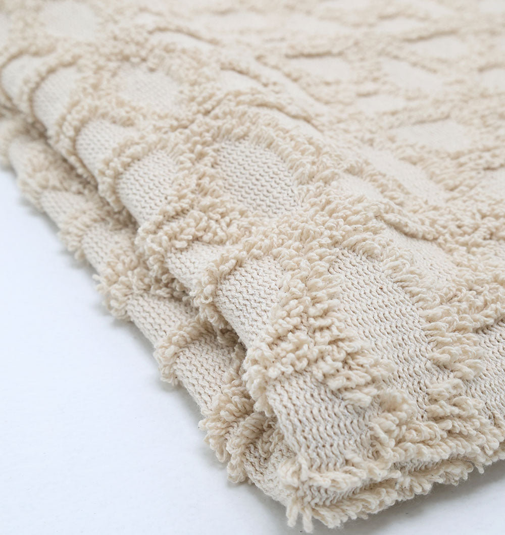 A close-up of the Ramsha Home Living Room Throw TAL 063 (130x175 cm), a natural-color cotton throw featuring a raised diamond pattern and soft tufted details—ideal for cozy living room décor.