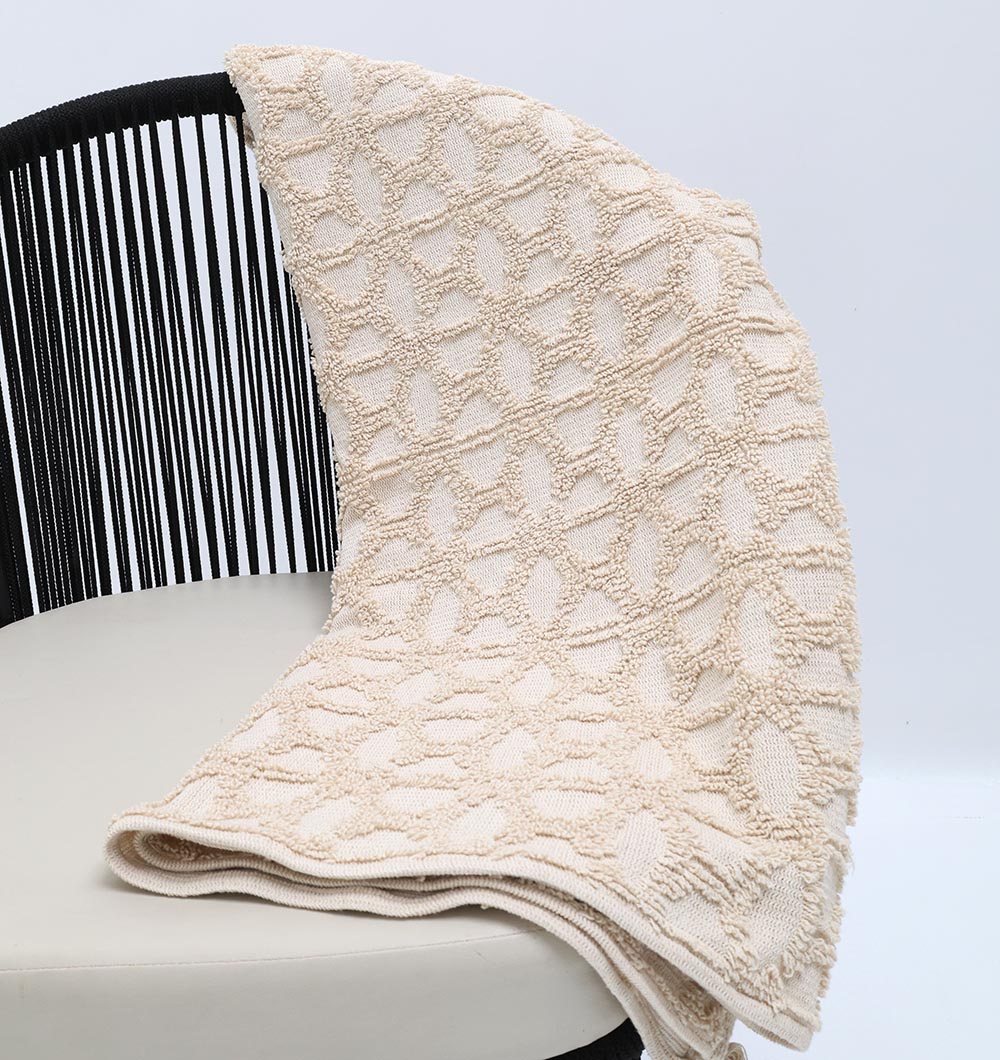 The Living Room Throw Natural Color Cotton Throws TAL 063 (130x175 cm) by Ramsha Home adds a geometric touch and cozy style to any modern space, draped over a black and white chair for inviting living room décor.