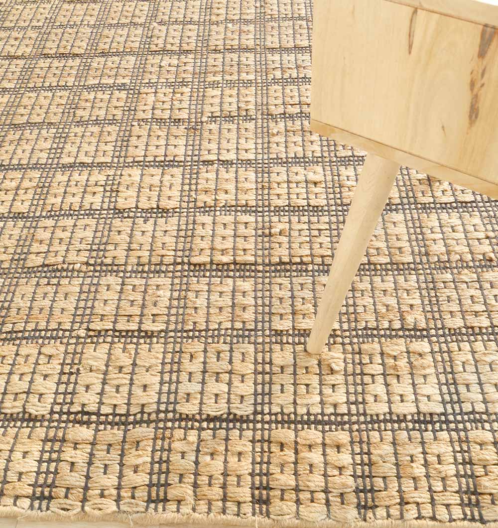 Close-up showing authentic craftsmanship where the rug meets accent furniture, adding character to the interior.
