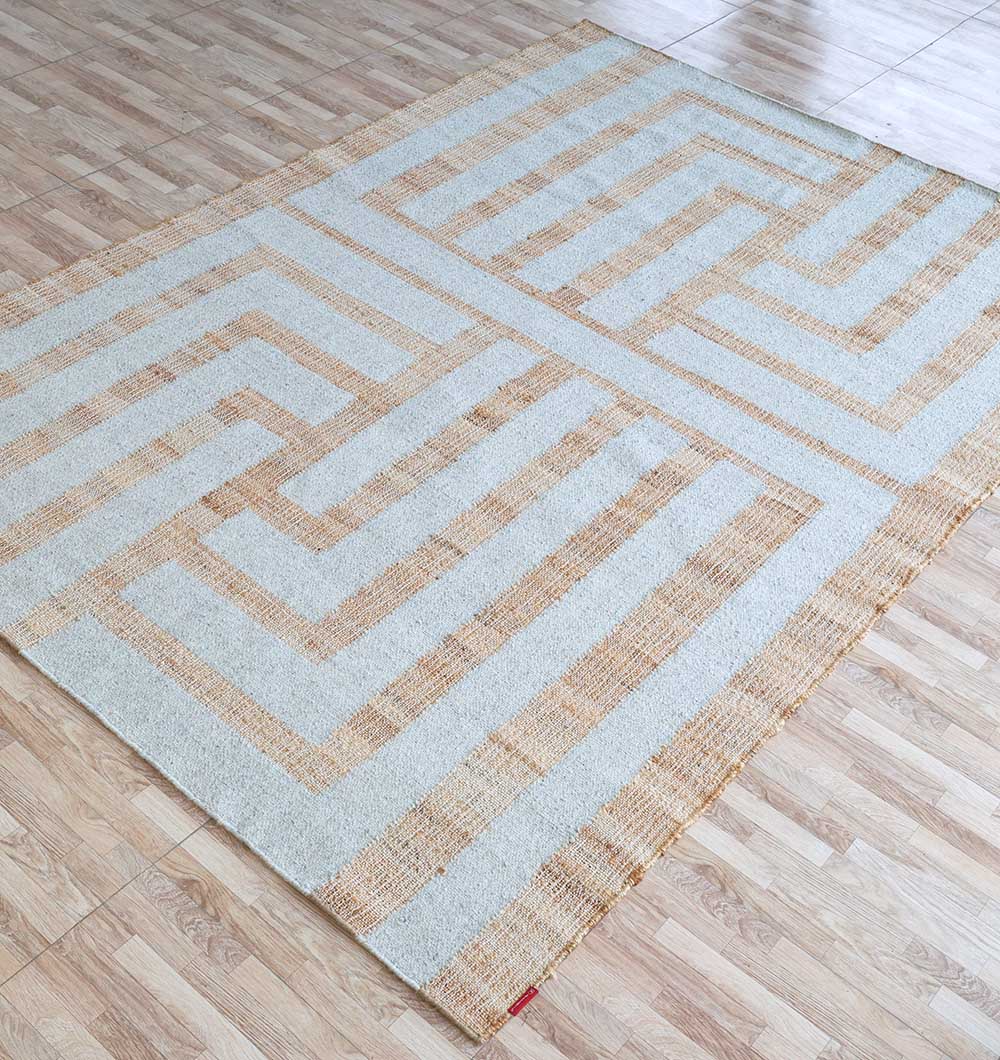 The Jute & Wool Natural Color Hand Woven Rug WR-036 by RAMSHA HOME, featuring a modern maze pattern in beige and light brown, adds a stylish geometric touch to light wood floors with its flat woven design.