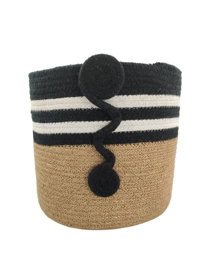 The Jute & Cotton Natural Handmade Basket - BS 004 (25x25cm) by Ramsha Home features a tan base, black top with two white stripes, and a wavy black decorative accent—ideal for toy storage or stylish nursery decor.