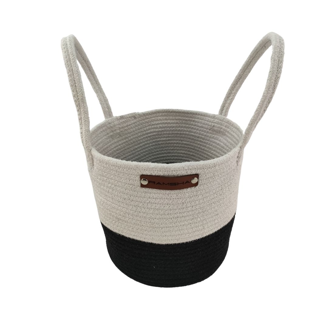 The Cotton White & Black Handmade Basket - BS 006 (25x25cm) by Ramsha Home is a two-toned basket with handles and a leather label—ideal for toy storage or as stylish nursery decor.
