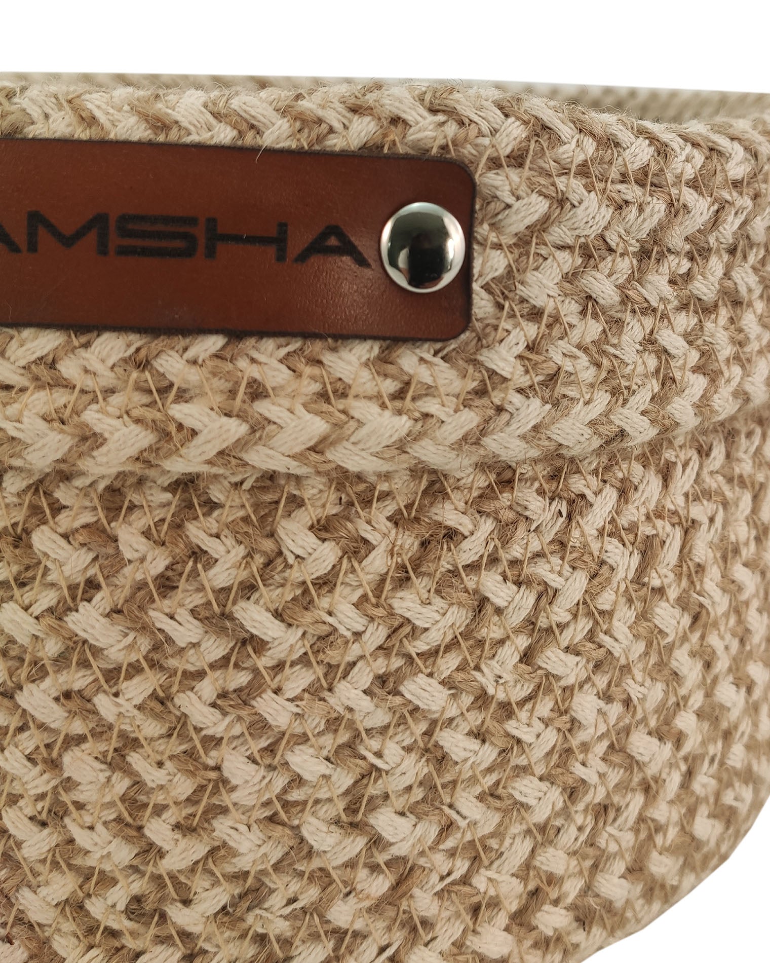 Close-up of the Ramsha Home Natural and White Handmade Jute and Cotton Basket (BS 008, 12x20 cm), featuring a textured zigzag weave and brown leather label—a stylish organizer from a luxury UAE brand.