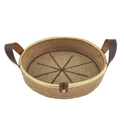 The Natural Jute Basket with Leather Handle- BS 011 (28x7cm) by Ramsha Home features a sunburst base, gold trim, and two brown leather handles—ideal as a stylish storage basket or kitchen organizer for your home.