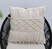 The Ramsha Home Natural Color Jute Cushion with Filler (45x45cm, CS 307) sits on a black woven chair against a plain light background, with a green leaf partially visible on the left.