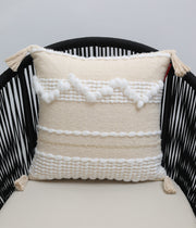 The Cream Color Home Decor Cushion - CS 313 A by Ramsha Home features premium cotton, white textured patterns, and tassels on each corner—a stylish accent piece to elevate your décor from this luxury UAE brand.