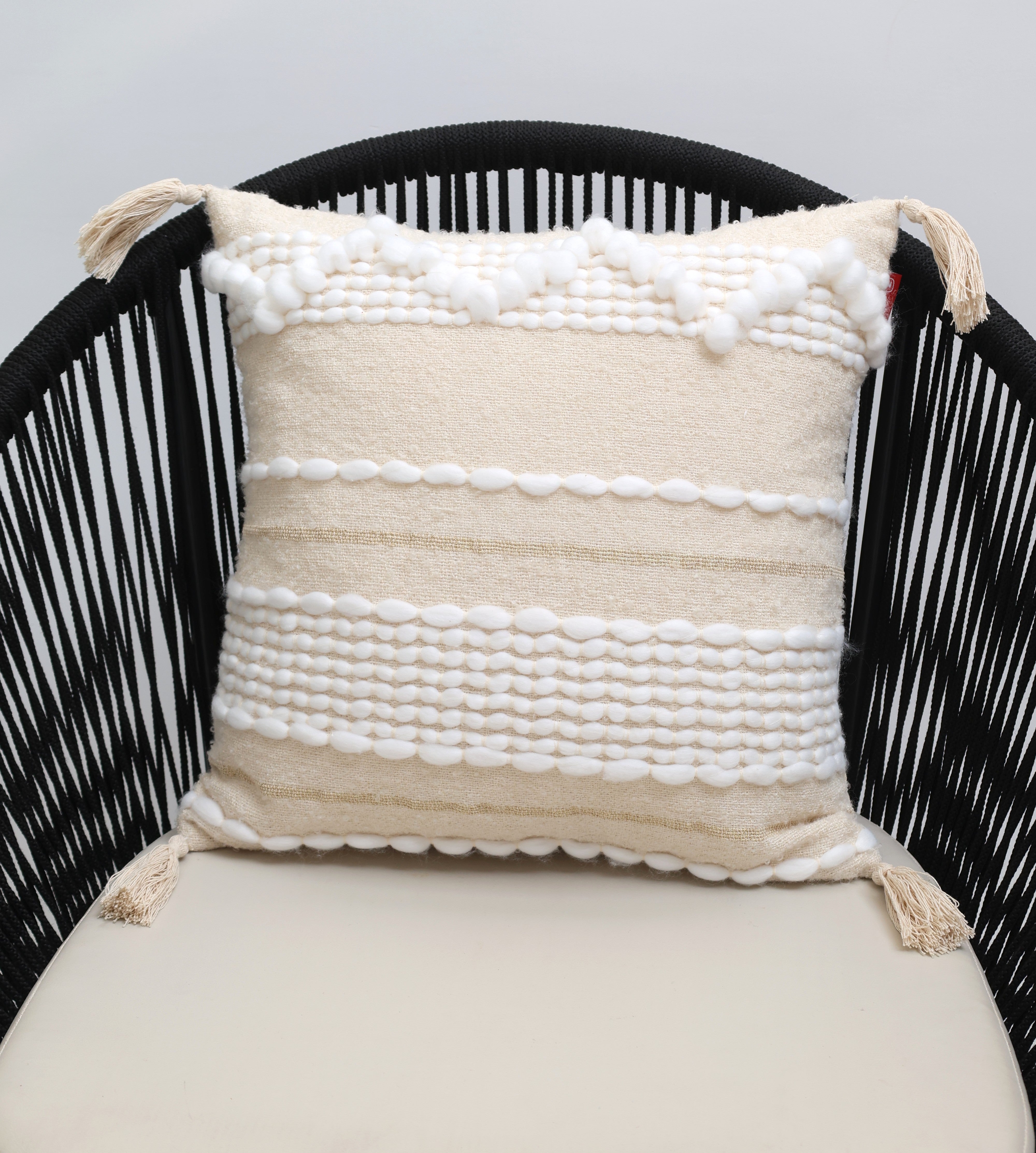 The Cream Color Home Decor Cushion - CS 313 B by Ramsha Home features cream and white cotton with tassels and raised woven patterns, perfect for enhancing your space. Ideal for adding a touch of luxury to chairs or sofas.