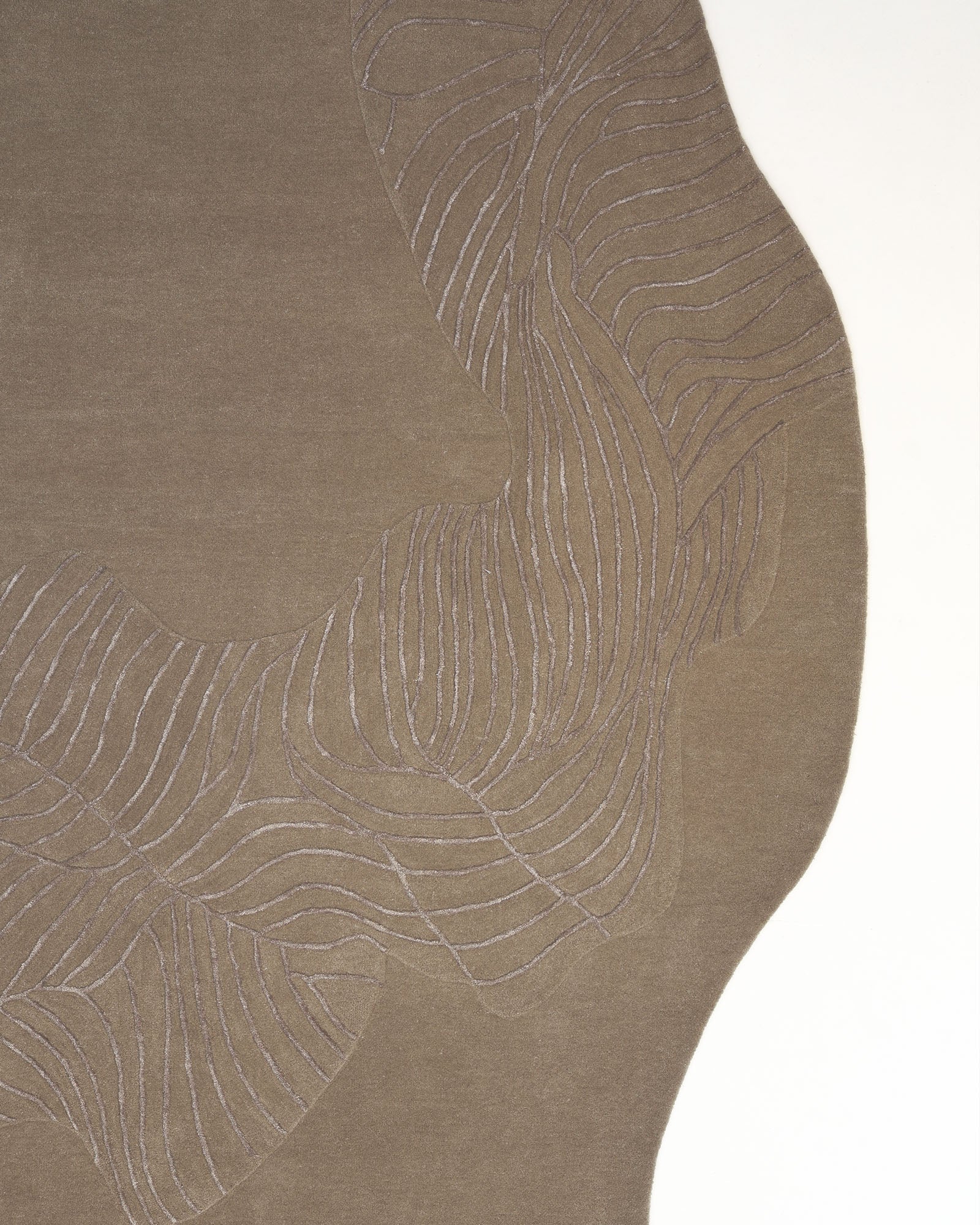 A close-up of the RAMSHA HOME Natural White Color Handmade Area Rug - HTWV-137 (200x300 cm) showcases its wavy-edged, irregular silhouette and subtle, flowing line patterns that evoke abstract leaves or waves. This modern wool rug is presented against a white background.