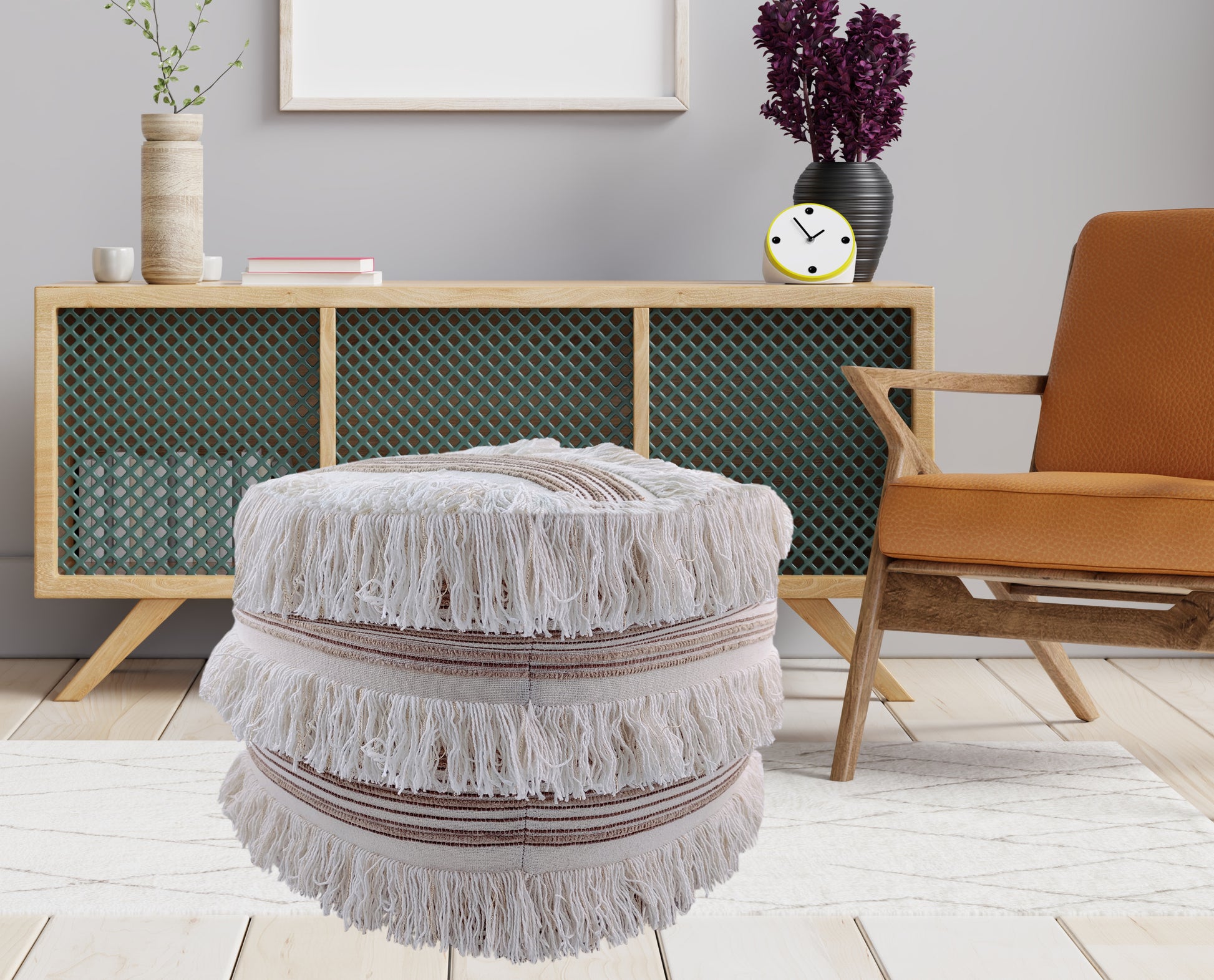 A cozy living room featuring the RAMSHA HOME Cotton Boho Pouf With Fringes PF-067, a wooden chair with an orange cushion, a boho sideboard with green panels, a vase of purple flowers, and a small smiling clock.