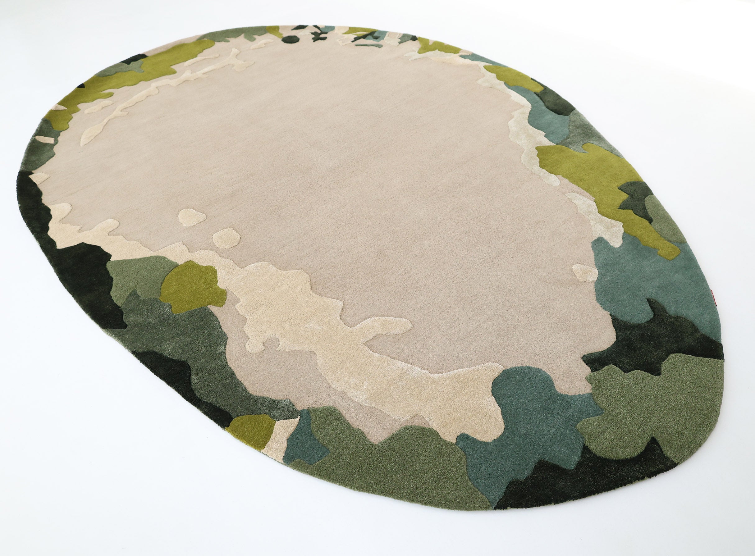 The RAMSHA HOME Terra Eclipse Oval Handmade Rug (HTWV-201) features an abstract topographical pattern in beige, green, olive, and dark gray, adding a modern touch to any space—especially striking on a white floor.
