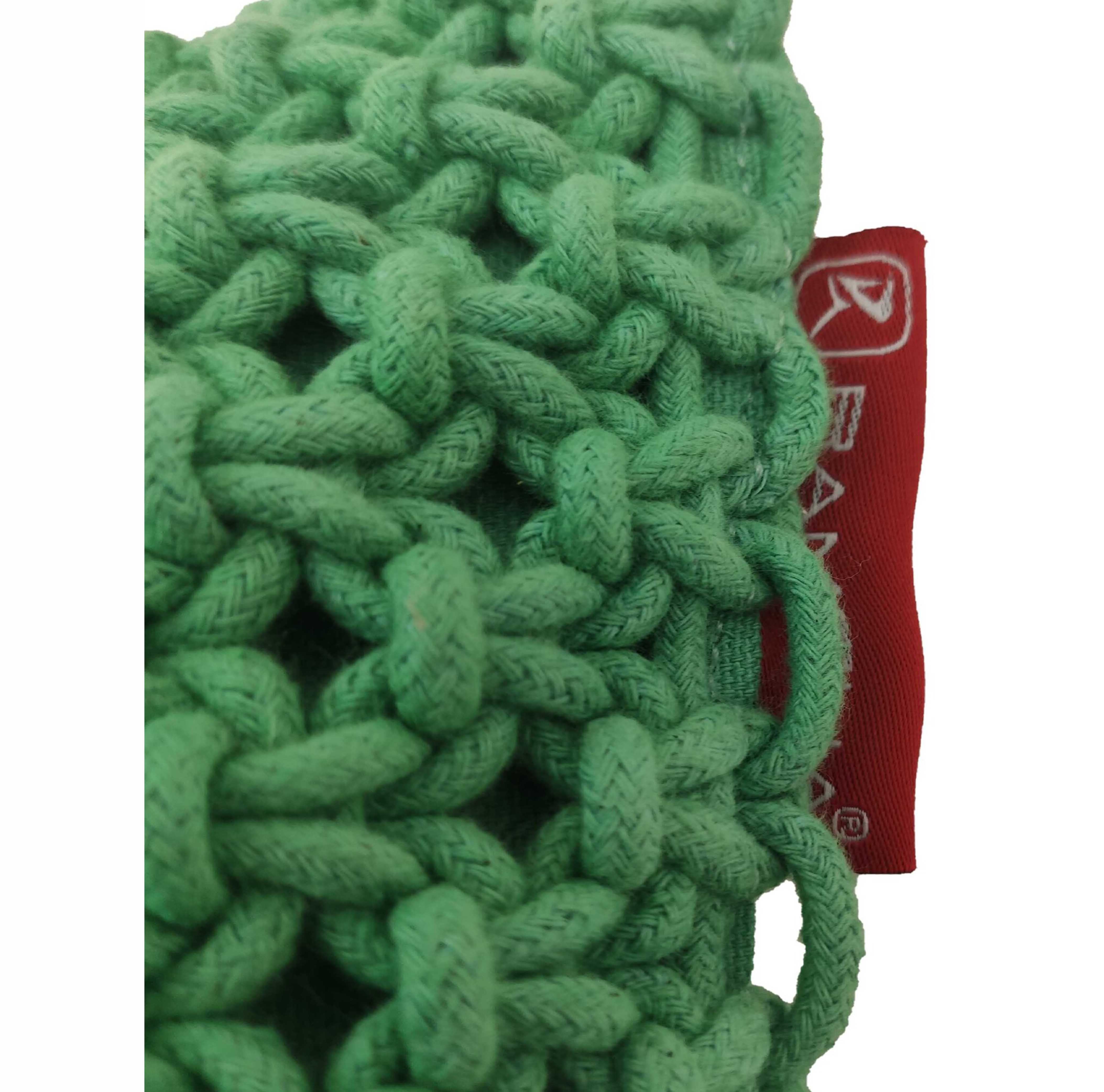 Close-up of the Macrame Cotton Cushion With Filler by RAMSHA HOME, showing green knitted fabric and a partially visible red tag with white text and logo on the right side.