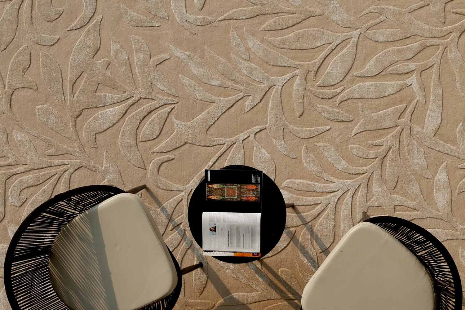 Neutral rug underneath a black chair and round table, enhancing the stylish interior decor.