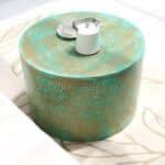 Round coffee table with turquoise dot pattern and golden base styled with a tea set