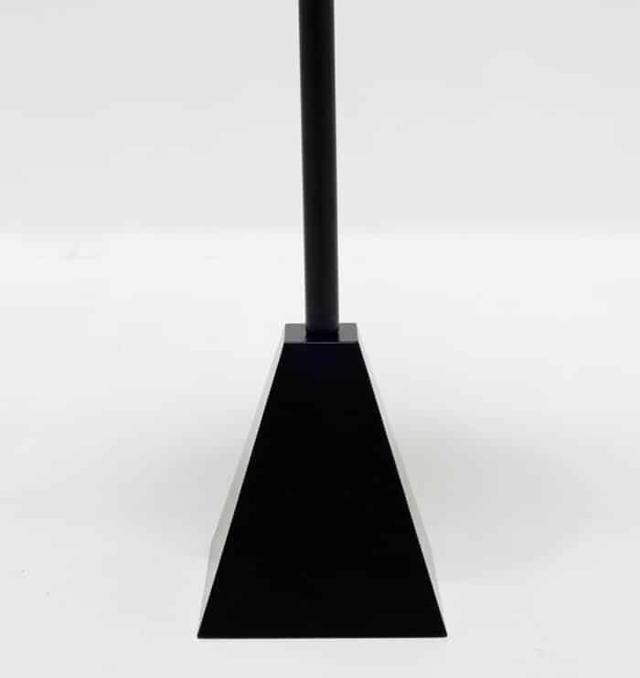 Close-up of pyramid-shaped metal base of modern black side table showing sleek matte finish