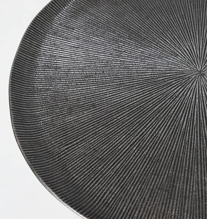 Close-up top view of modern black metal side table showing textured surface and matte finish