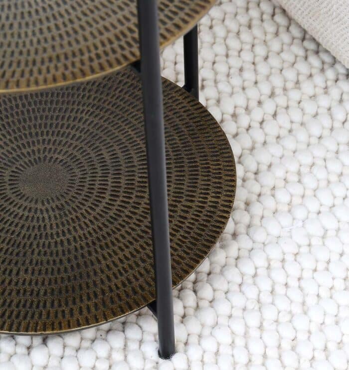 Close-up of round coffee table showing textured wood top and black iron base details
