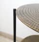 Close-up of round wooden coffee table surface with natural grain detail and black metal base
