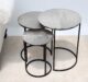 Top angled view of modern round coffee table showing aluminium top texture and black iron legs