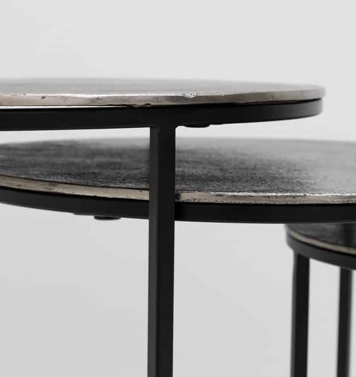 Side close-up of set of 3 modern nesting side tables showing antique brass tops and black iron bases