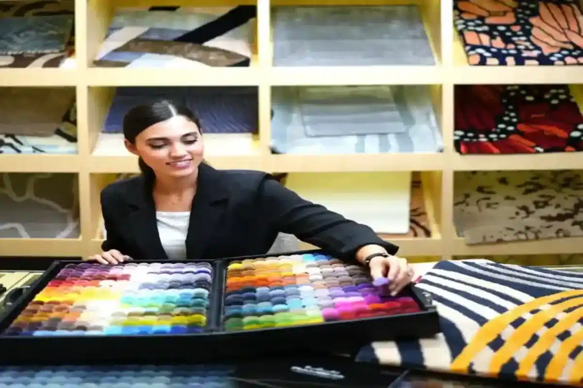 Person selecting colors from ARS Colors pom box for rug and carpet design