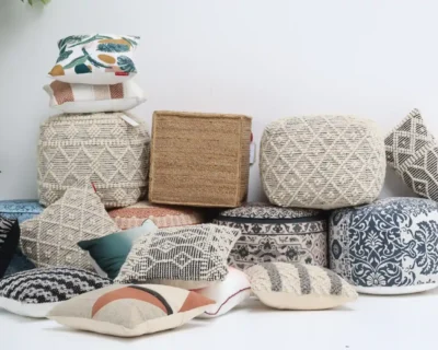 Assorted handmade and machine-made poufs and cushions arranged together for the blog ‘Handmade Poufs vs Machine-Made: Which Is Worth Buying?’