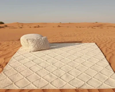 Jute rug and jute cushion displayed in desert setting showcasing woven texture