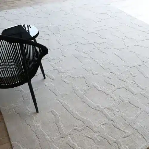 Minimalist rug in soft neutral tones with simple, clean design placed in a modern living room