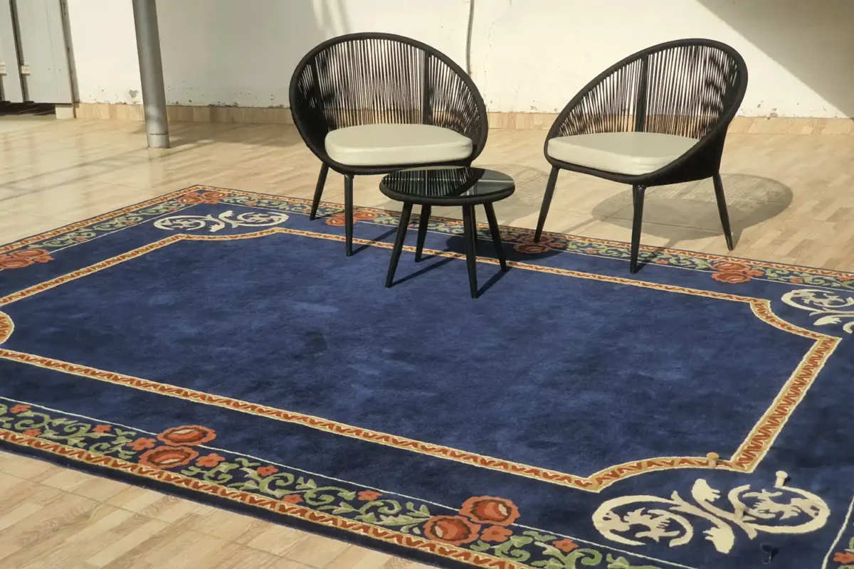 Traditional blue rug with classic patterns placed under a chair and side table