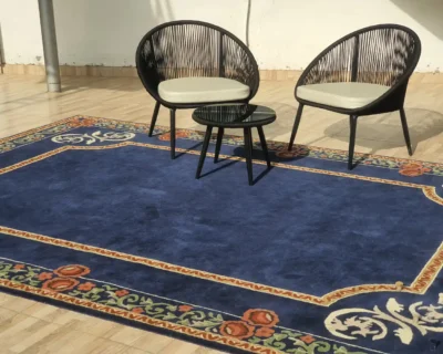 Traditional blue rug with classic patterns placed under a chair and side table