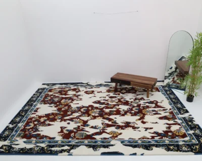 Traditional floral rug in a rectangular shape with dark blue and red botanical patterns on a cream base, featuring a classic, ornate border.