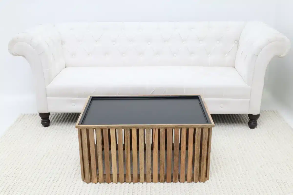 Side table positioned in front of a sofa demonstrating ideal height and sizing for living room furniture