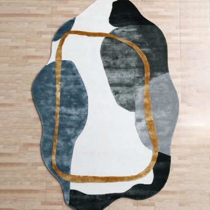 A Modern Shaped Rug with an irregular organic silhouette, featuring large charcoal and blue-grey color blocks and a hand-carved gold outline.