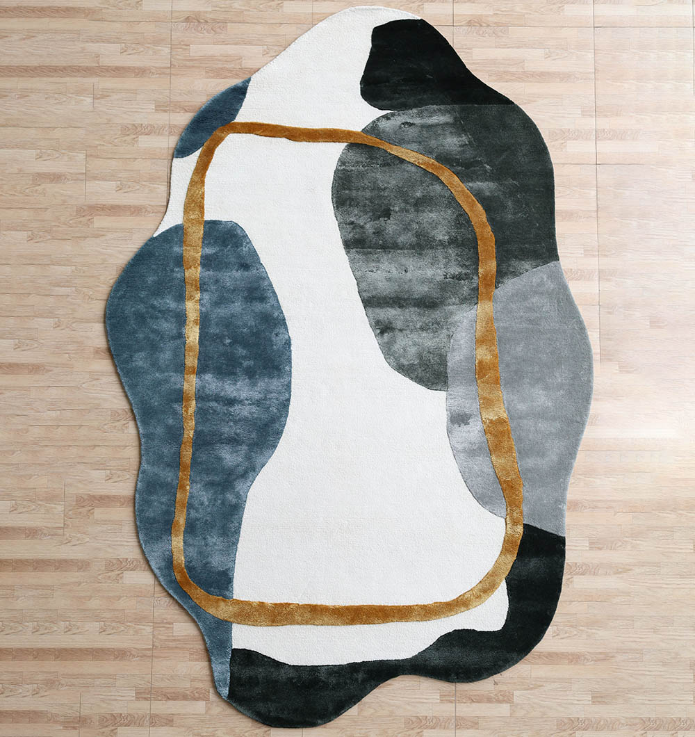 Modern Shaped Rug - HTV 24 A Modern Shaped Rug with an irregular organic silhouette, featuring large charcoal and blue-grey color blocks and a hand-carved gold outline.