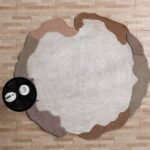 A Handmade Modern Shaped Rug in white and brown with a unique spiral carved center and irregular organic borders.